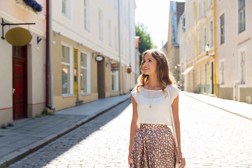 Une femme marchant dans une rue pavée bordée d’immeubles. 3