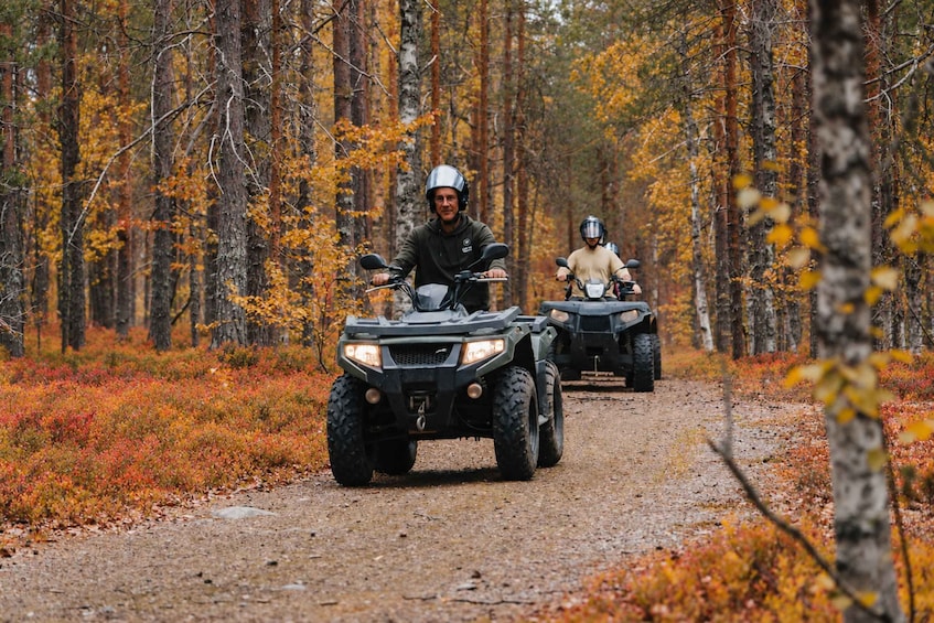 Deux personnes conduisent des quads sur un sentier forestier. 1