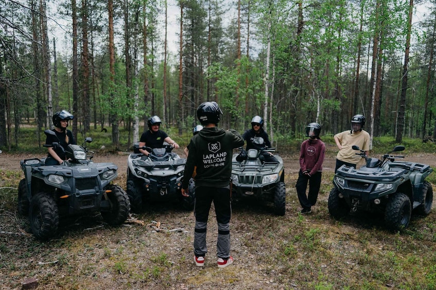 Un groupe de personnes conduisant des quads dans une zone boisée. 2