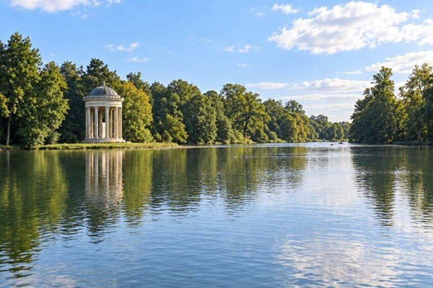 A tranquil lake with a gazebo and dense trees in the background. 4