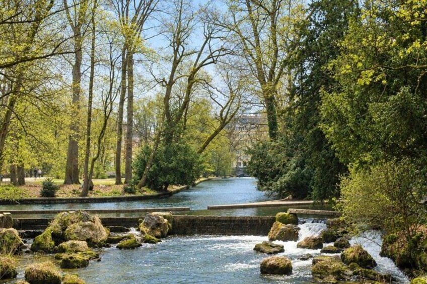 A river flowing through a park with trees and rocks. 3