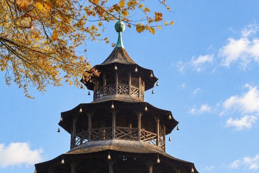 A multi-tiered pagoda with a green spire, surrounded by autumn leaves. 2