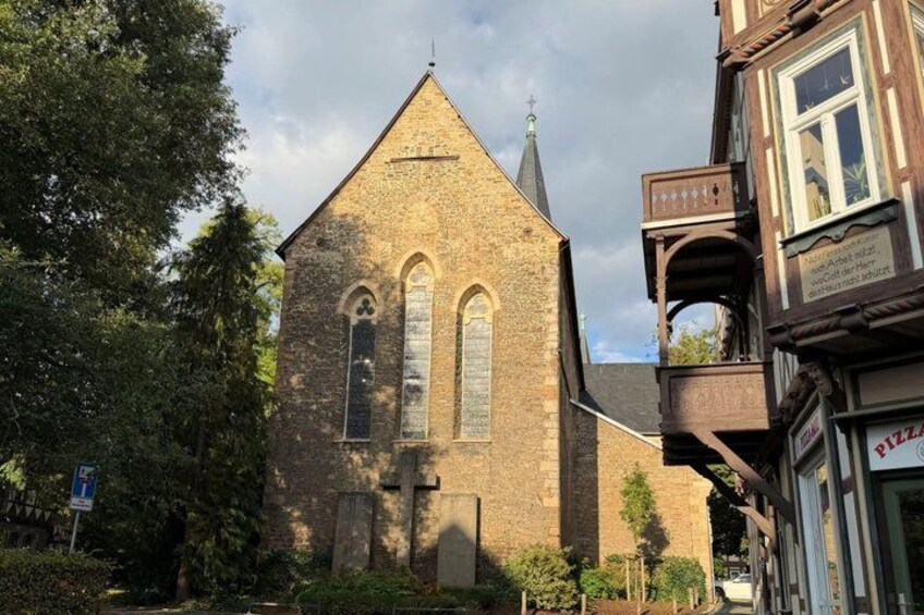 A historic church with a pointed steeple, a brick facade, and arched windows. 5
