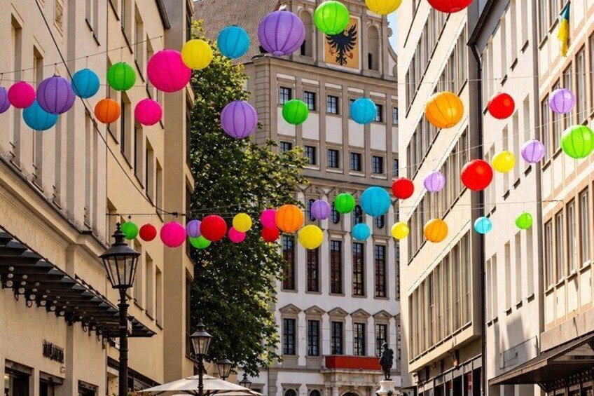 A street with colorful paper lanterns hanging between buildings. 4