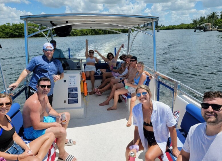 A group of people on a boat with a canopy, surrounded by water and greenery. 2
