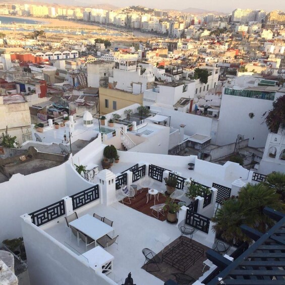 A rooftop terrace with outdoor furniture and a cityscape in the background. 2