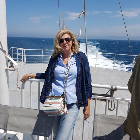 A person standing on a boat deck with the ocean in the background. 3