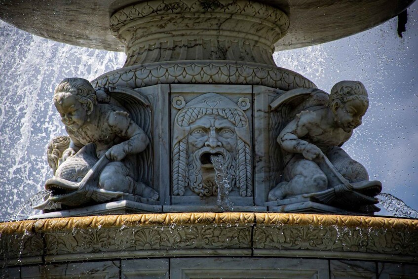 Une fontaine en pierre ornée de deux putti et d’un panneau décoratif central. 3