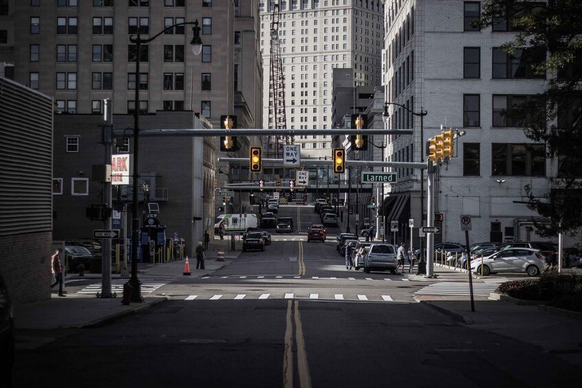 Une intersection urbaine avec des feux de signalisation, des panneaux indiquant la direction à sens unique et un panneau de rue indiquant « Larned ». 1