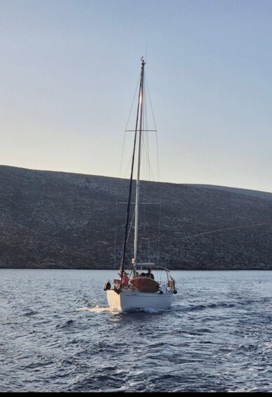 A sailboat on calm water with a mountainous backdrop. 3