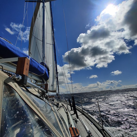 A sailboat with a blue tarp and a person standing on the deck. 2