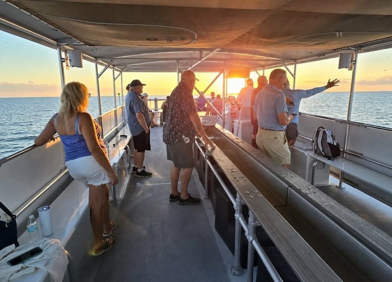 A group of people on a boat during sunset. 3