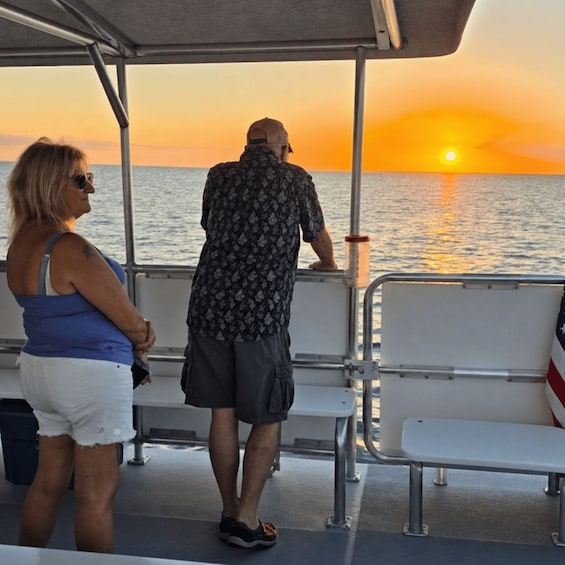 A man and a woman on a boat during sunset. 1