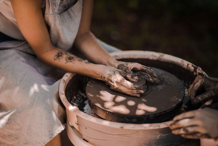 A person shaping clay on a pottery wheel. 2