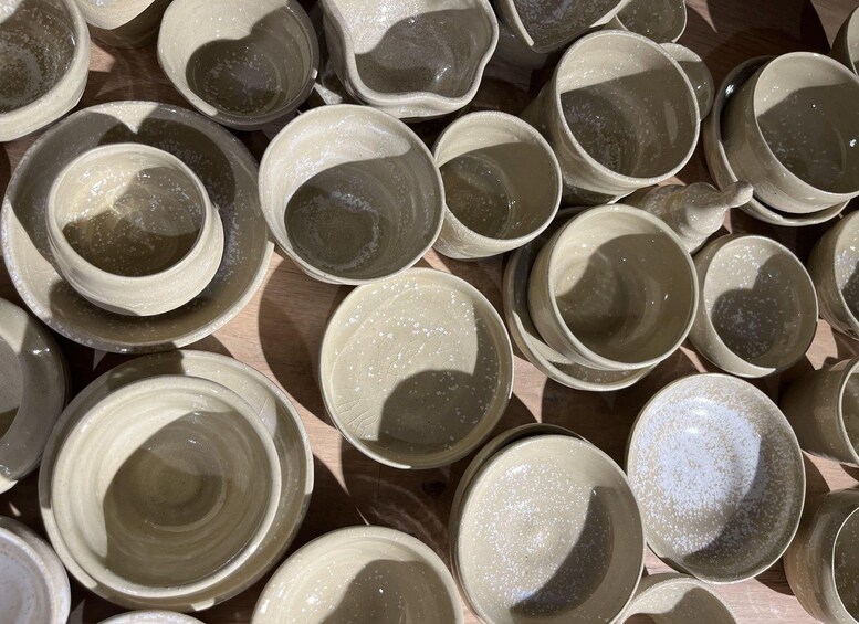 A collection of ceramic bowls with a speckled glaze, arranged closely together on a wooden surface. 4