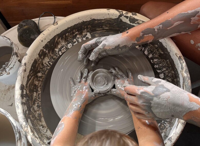 A person shaping clay on a pottery wheel. 3
