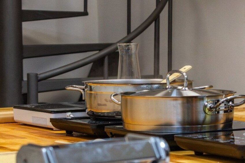 A kitchen with a gas stove, pots, a kettle, and a coffee maker. 5