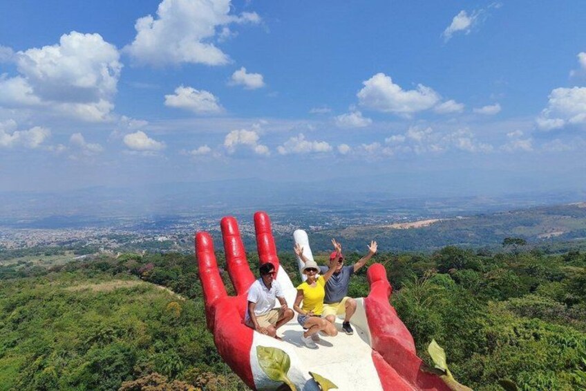 People on a red and white hand-shaped structure with a cityscape in the background. 4