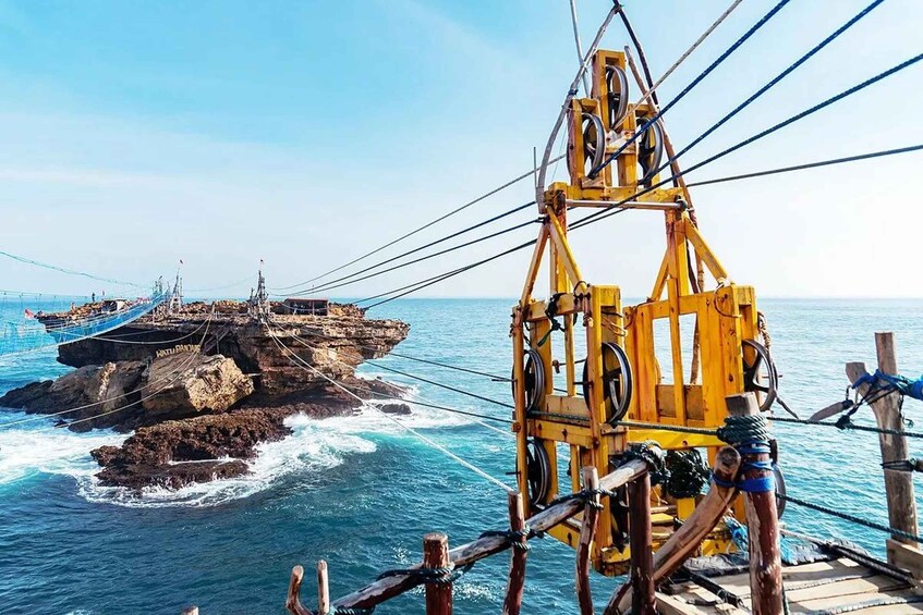 A rocky coastline with a yellow crane and a shipwreck. 3