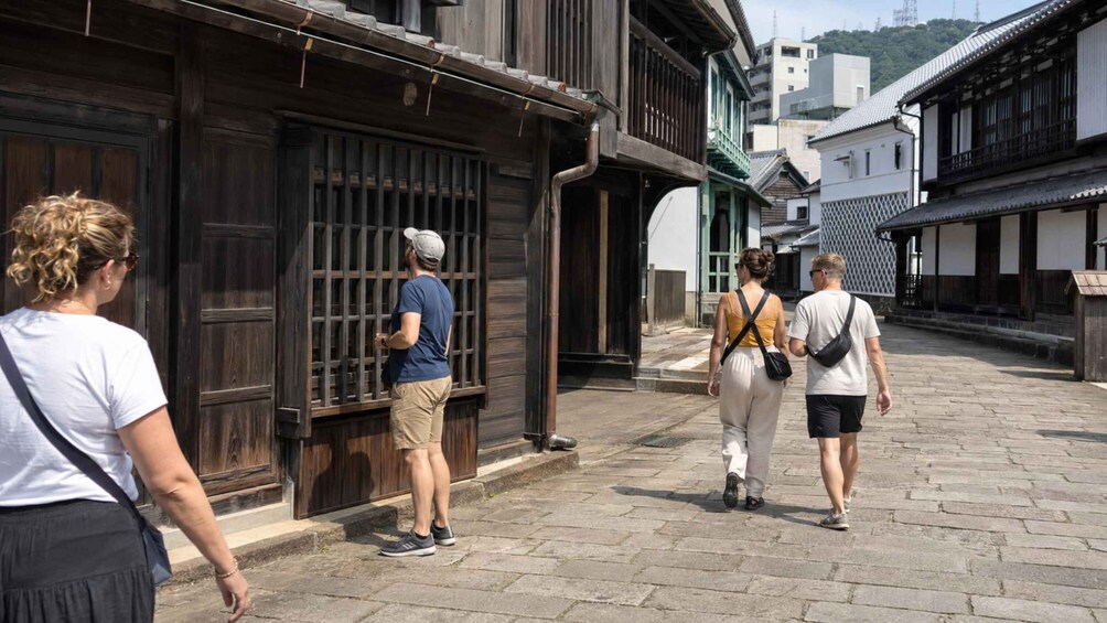 A group of people walking on a cobblestone street in a traditional Japanese town. 2