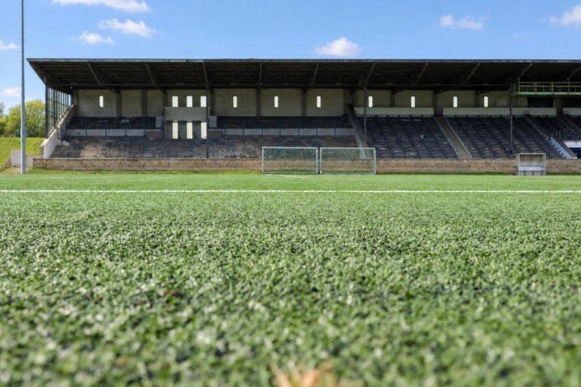 A soccer field with bleachers and a goalpost. 4