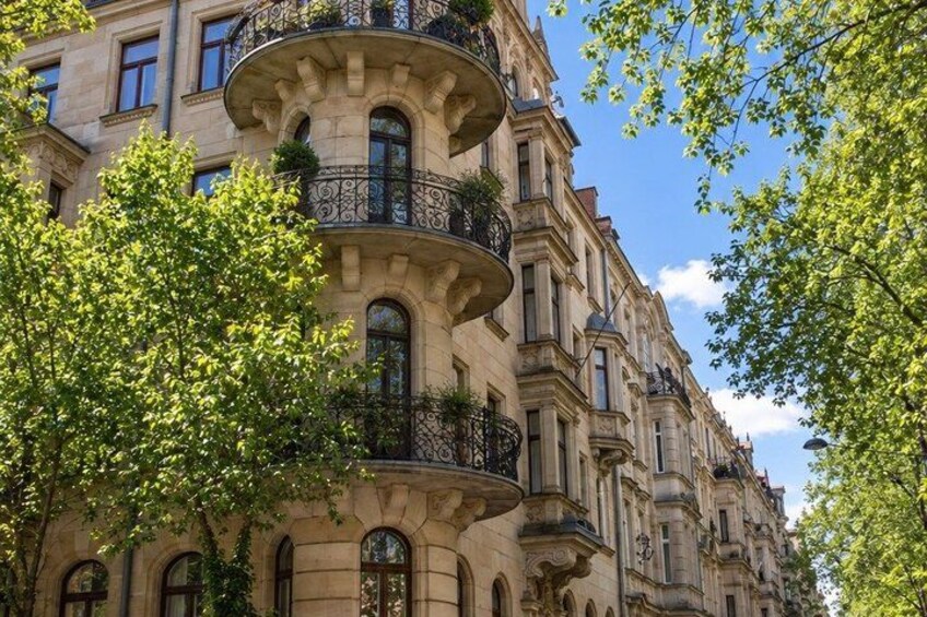 A row of classical European-style buildings with ornate balconies and arched windows. 5