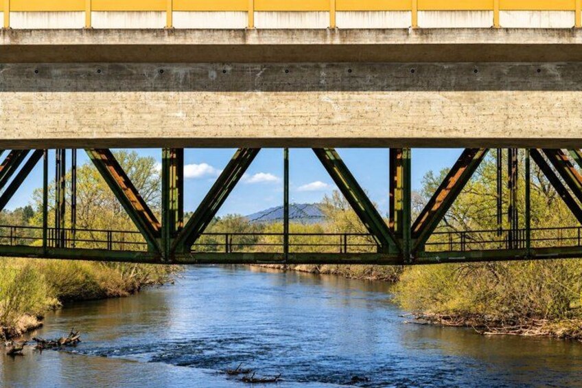 A bridge over a river with a mountainous background. 2