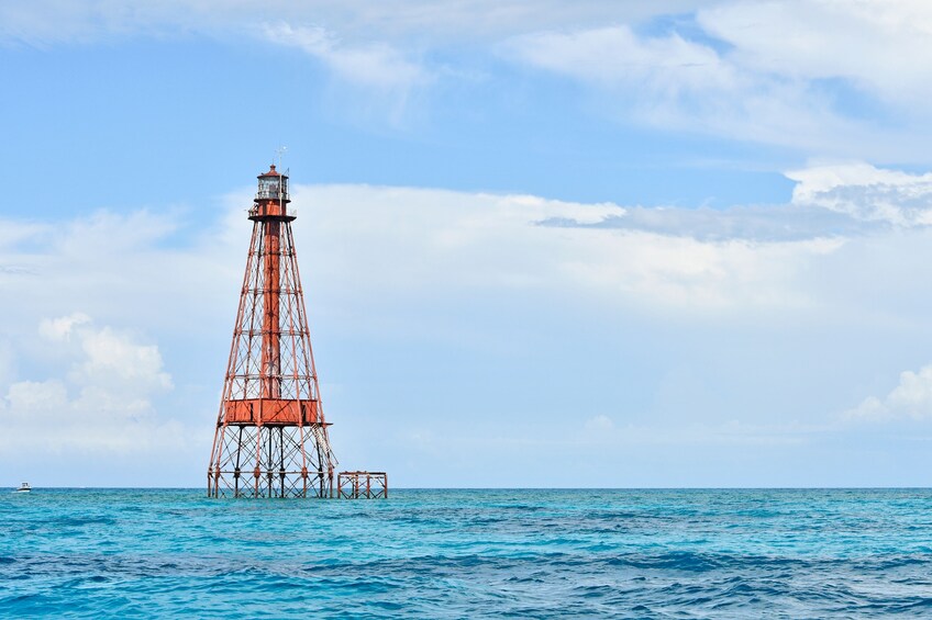 A red lighthouse on a pier in the ocean. 1