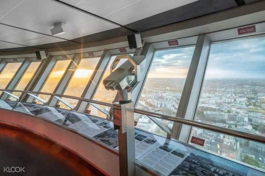A panoramic view from a high vantage point, likely a train or cable car, overlooking a cityscape with buildings and a clear sky. 3