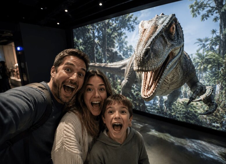 A family taking a selfie with a large dinosaur model in the background. 1