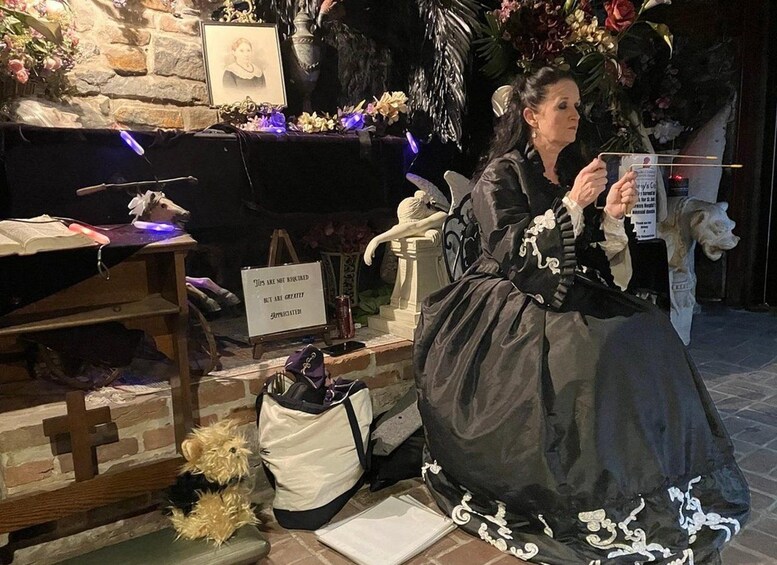 Una persona con vestimenta de época en una exposición de museo, con un letrero que dice 'Se agradecen las propinas, pero no son obligatorias'. 1