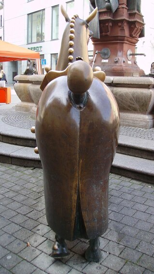 Eine bronzene Skulptur einer stilisierten Tierfigur mit einem großen, abgerundeten Rücken und einem kleinen Kopf. 5