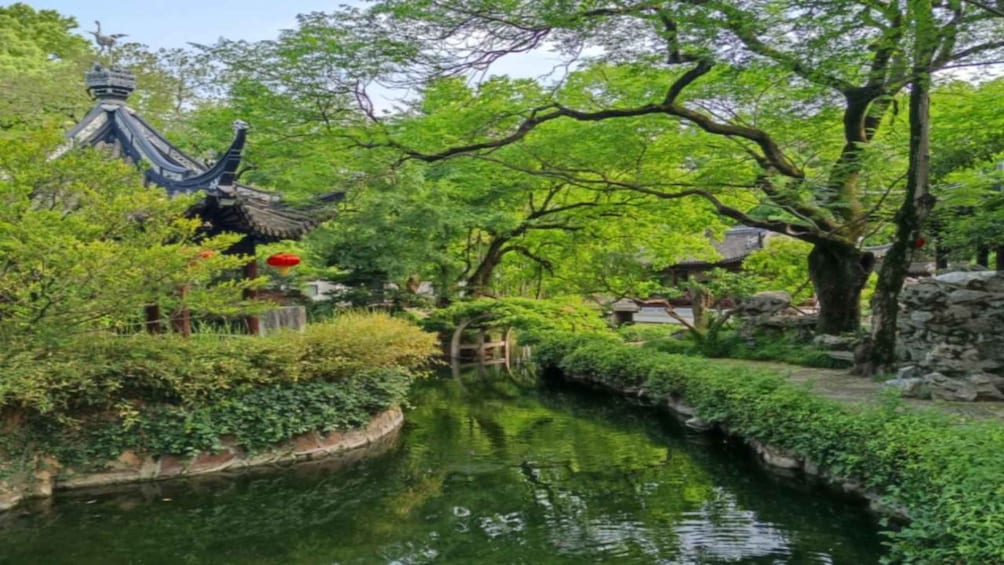 A traditional Chinese garden with a water canal, lush greenery, and a pagoda. 3