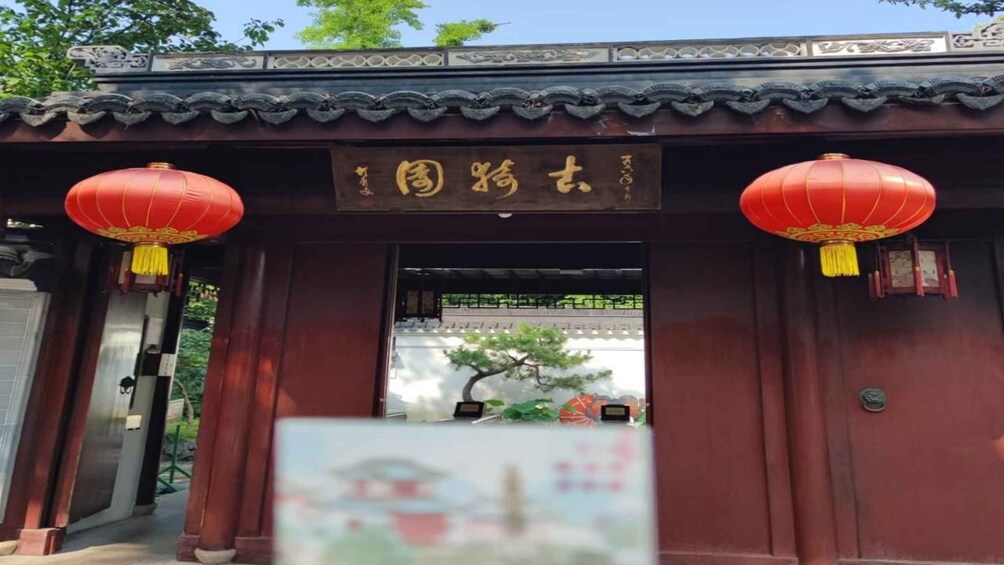 A traditional Chinese gate with red lanterns and a sign with Chinese characters. 1