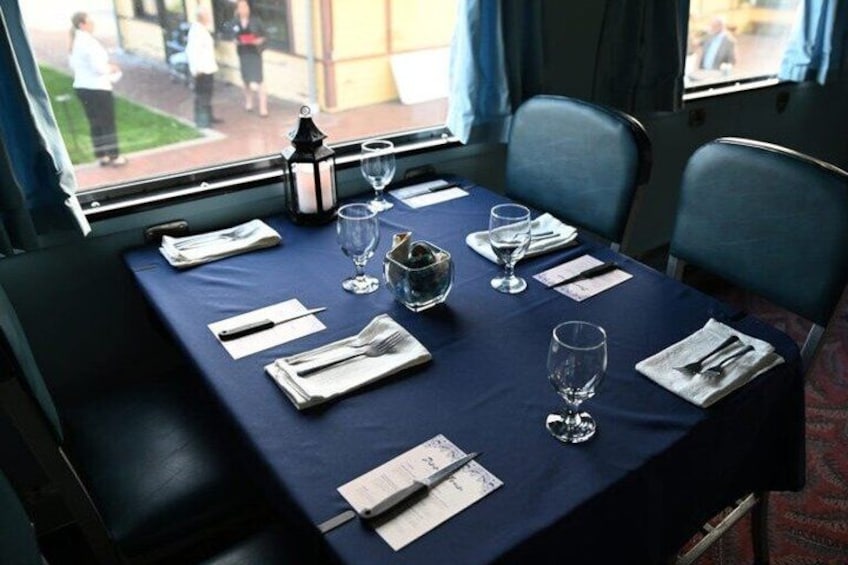 A table set for dining with a blue tablecloth, white napkins, and clear glasses. 5