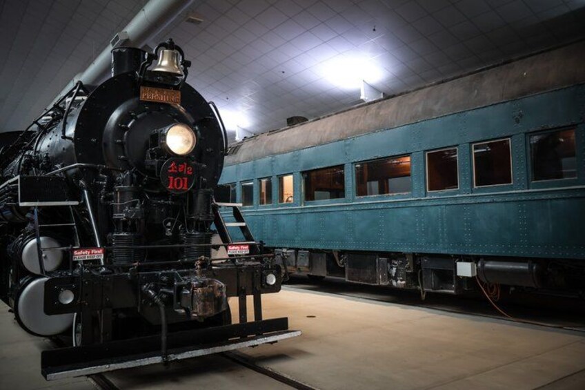 A steam locomotive with the number 101, a blue passenger car, and a platform. 3