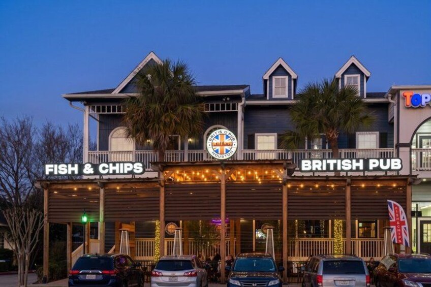 A waterfront building with signs for 'Fish & Chips' and 'British Pub.' 1