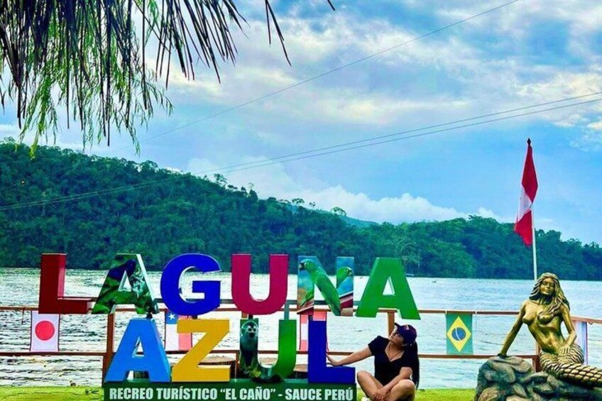 A sign with colorful letters spelling 'LA GUNA AZUL' and a statue of a mermaid. 1