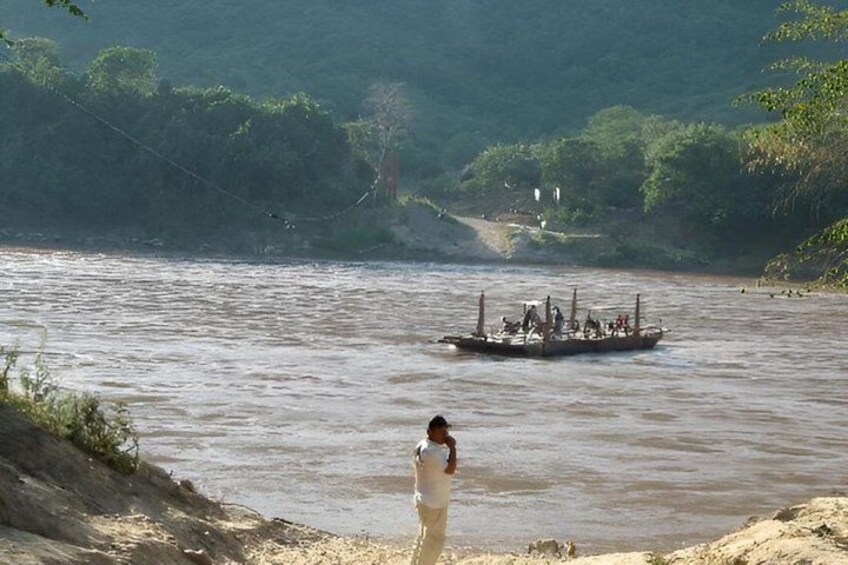 A river with a boat and a person standing on the bank. 3