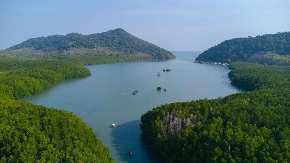 A large body of water surrounded by dense forested hills. 2