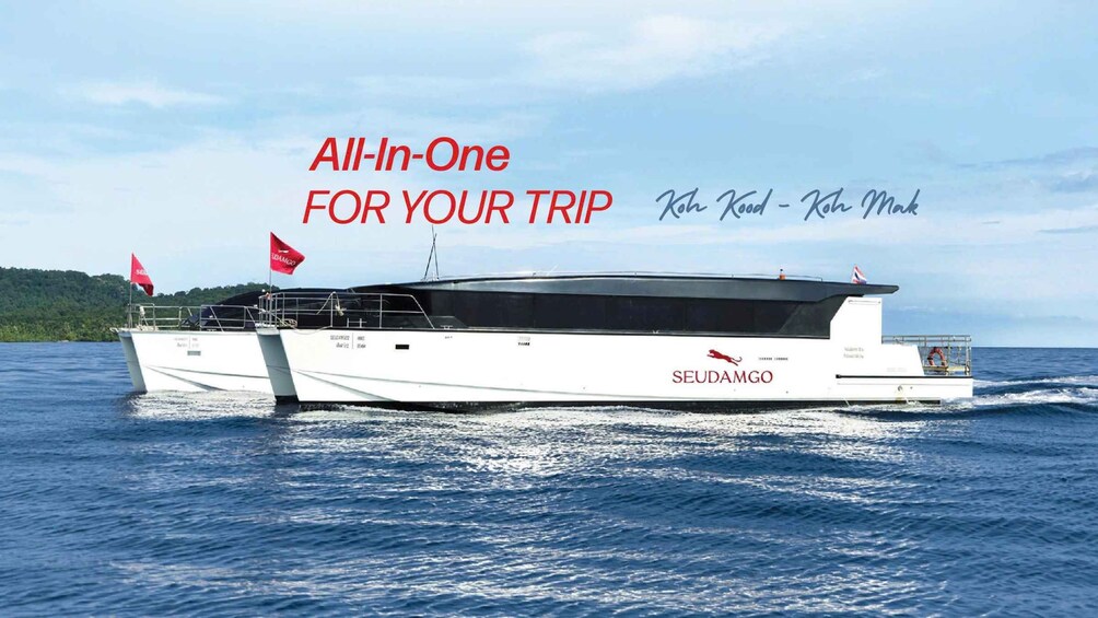 A white yacht with the name 'SEUDA MGO' on its side, sailing on blue water with a clear sky. 1