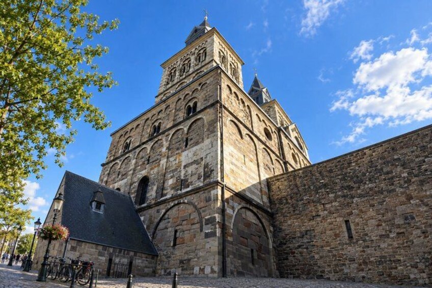 A historic stone building with a prominent tower and arched windows. 5