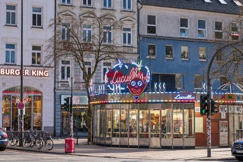 A storefront with a neon sign, bicycles parked outside, and a traffic light. 5