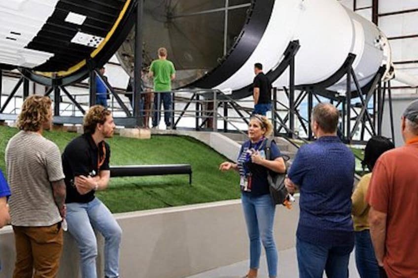 A group of people observing a large telescope structure. 4