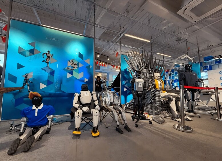 A robot with a blue shirt and a person in a black helmet sitting on a platform. 3