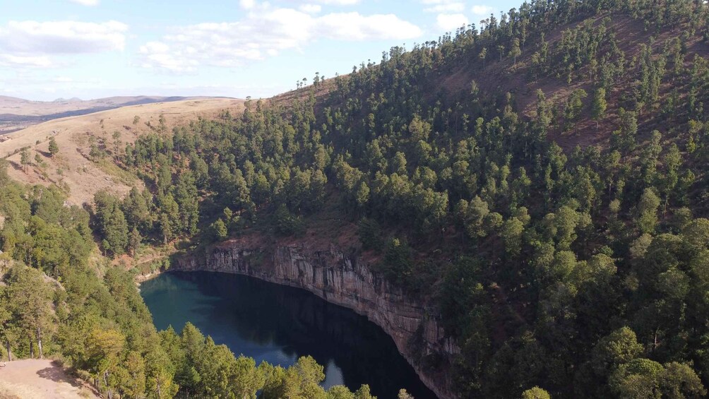 Ein tiefes Blauwassersee inmitten dicht bewaldeter Schlucht. 2