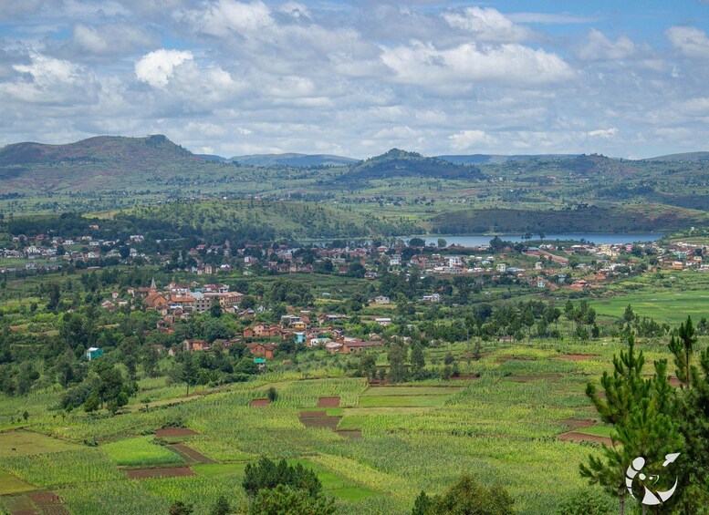 Ländliche Landschaft mit terrassierten Feldern, einer kleinen Stadt und sanften Hügeln im Hintergrund. 5