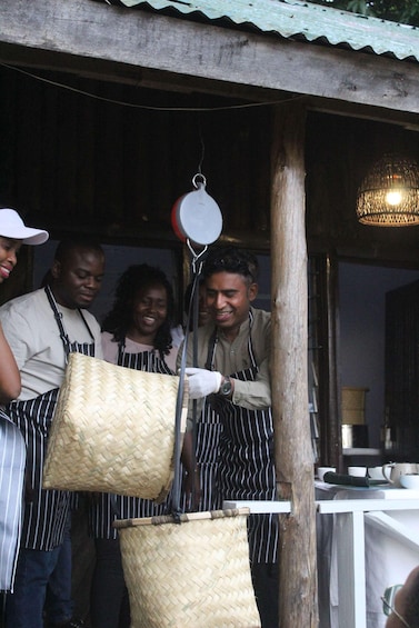 A group of people in aprons, a hanging basket, and a wooden structure. 5