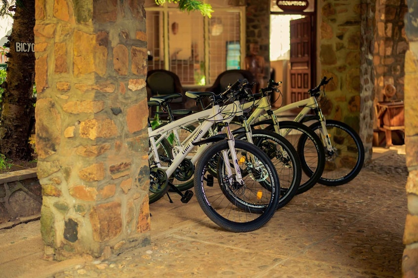 A stone archway with bicycles parked under it. 3