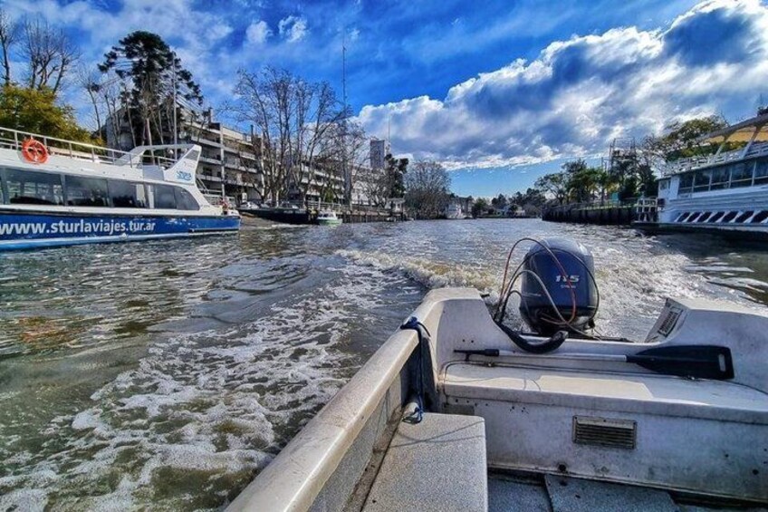 A boat moving through a river with buildings and trees in the background. 4